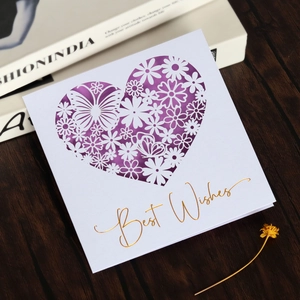 Close-up of heart-shaped hollow butterfly greeting card with gold foil Best Wishes text