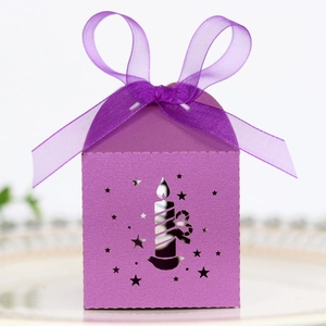 Detail of purple laser-cut Christmas candy box with candle star patterns and a ribbon bow