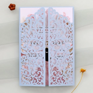 Macro view of laser-cut invitation with floral card on light grey gauze background