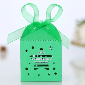 Detailed view of green laser-cut gift box featuring star patterns and a matching organza ribbon