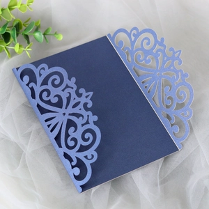 Laser-cut navy blue wedding invitation cover with elegant vine patterns on pearl paper