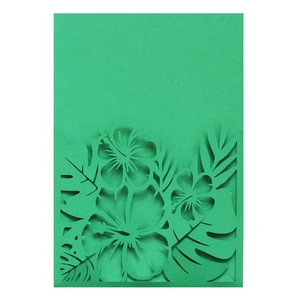 Détail de l'invitation avec feuilles tropicales vert foncé découpées au laser