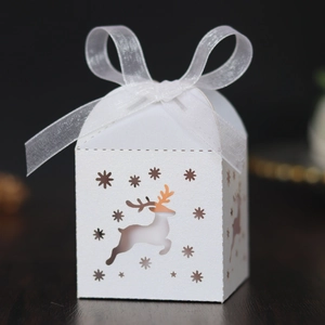 Close-up of white Christmas reindeer hollow-out candy box with white organza ribbon bow