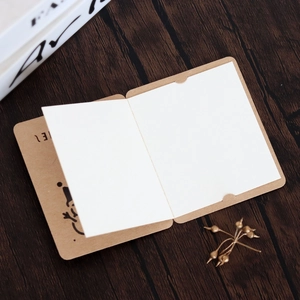 Close-up of minimalist kraft paper snowman greeting card with blank white insert on wood
