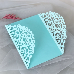 Detail of laser-cut wedding invitation pocket in light blue with floral scroll patterns