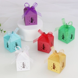 Macro detail of laser-cut star and candle patterns on colorful paper gift boxes