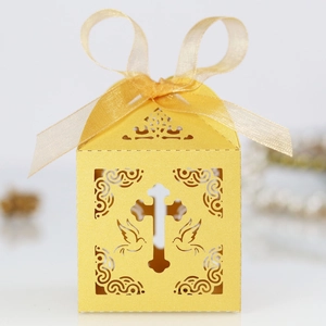 Detail of yellow laser-cut gift box with cross and dove patterns on pearlescent paper