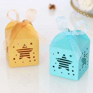 Detail of yellow and blue star-shaped gift boxes with ribbons on white background
