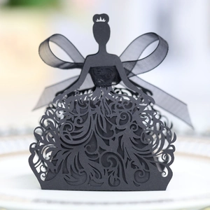 Detailed laser-cut black bride silhouette candy box with decorative ribbon on a plate