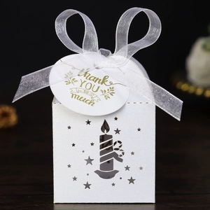 Close-up of white laser-cut gift box with glitter finish and star candle patterns
