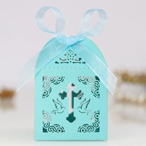 Detail of laser-cut gift box with cross and dove patterns in light blue pearl paper