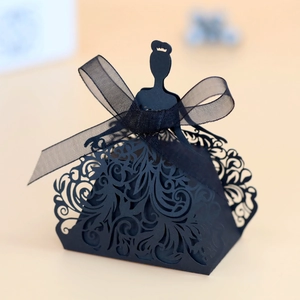 Macro detail of laser-cut black hollow party favor box with sheer organza ribbon bow