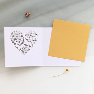 Close-up of laser-cut butterfly floral card with white outer and gold inner paper