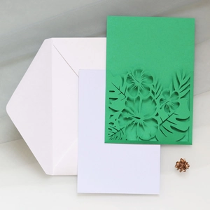 Détail du faire-part vert découpé au laser avec enveloppe blanche et carte intérieure