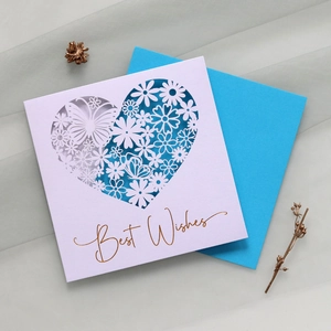 Detail of laser-cut heart greeting card with butterfly patterns and gold Best Wishes text
