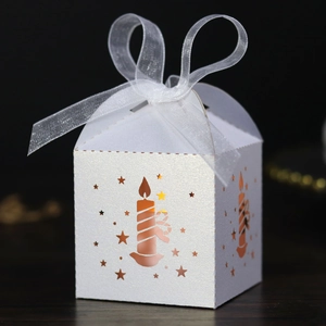 Detailed view of white Christmas gift box with laser-cut stars and white organza ribbon bow