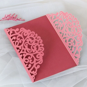 Detail of laser-cut floral pattern on wine red wedding invitation cover sleeve