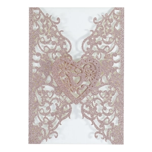Macro view of laser-cut glitter paper wedding invitation with floral heart design