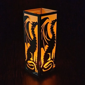 Black rectangular dinosaur paper lantern with warm orange glow for festive decor