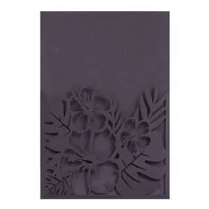 Vue macro de l'invitation de mariage violet foncé avec découpe laser de feuilles de monstera