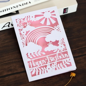 Détail d'une carte d'anniversaire découpée au laser avec arc-en-ciel et insert rose doux