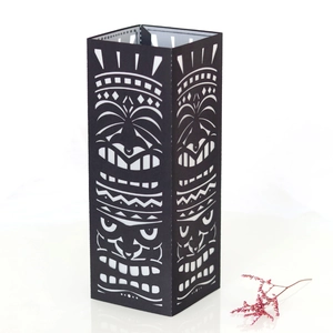 Detail showing Tiki tribal mask hollowed out pattern on a black square paper lampshade