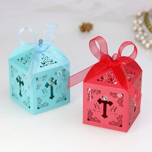 Detail of laser-cut gift boxes with cross and dove patterns and matching silk ribbons