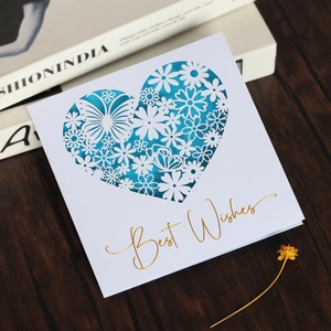 Detail of laser-cut heart pattern and gold foil Best Wishes text on a greeting card