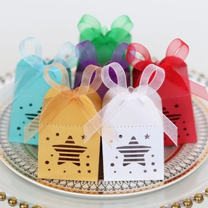 Close-up of star cut-out gift boxes with ribbons on a decorative ceramic plate