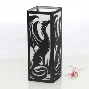 Detailed close-up of a black dragon paper lantern with intricate laser-cut tree silhouettes