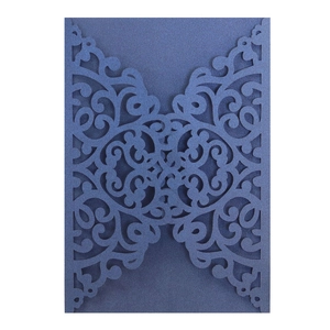 Detail of navy blue laser-cut wedding invitation with elegant pearlescent floral patterns