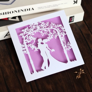 Detailed laser-cut wedding card featuring a silhouette of a couple on purple background