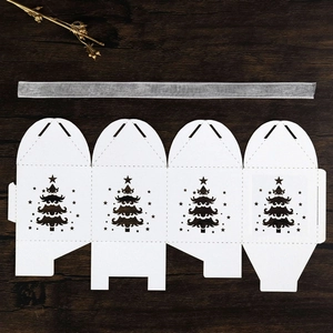 Flat lay view of laser-cut Christmas tree candy box with a silver satin ribbon detail