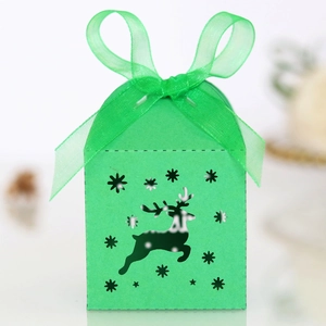 Detail of green laser-cut Christmas reindeer candy box with a green organza ribbon bow