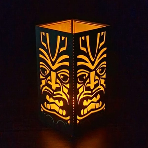 Tiki style black lantern with warm orange light and hand-stitched details