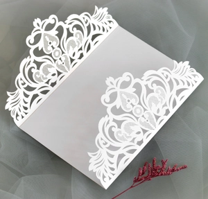 Détail macro d'une carte d'invitation découpée au laser avec motifs de cœurs et vignes