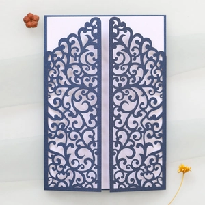 Detailed laser-cut vine patterns on dark blue pearlescent paper invitation card