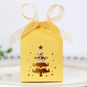 Detail of laser-cut gold Christmas tree gift box with shimmering texture and ribbon