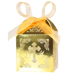 Macro view of laser-cut cross and dove patterns on golden cardstock favor box