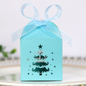 Detail of laser-cut Christmas tree candy box in light green with a satin ribbon bow
