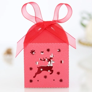 Detail of red Christmas favor box with hollow reindeer cutout and silk ribbon
