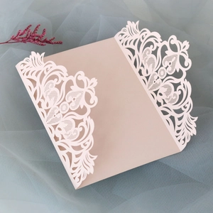 Détails de découpe laser motifs cœurs et fleurs sur invitation de mariage rose élégante