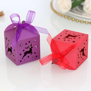Close-up of laser-cut reindeer and stars on red and purple festive candy gift boxes