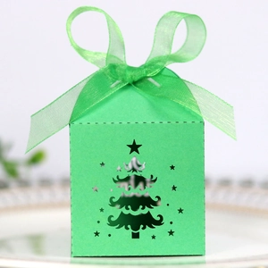 Detail of laser-cut green Christmas tree candy box with an elegant sheer ribbon bow