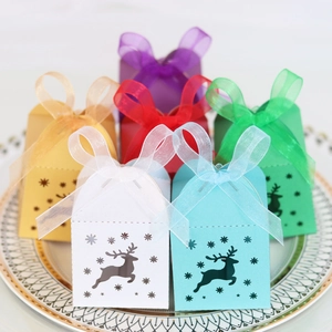 Detail of laser-cut reindeer candy boxes in multiple colors with organza ribbon bows