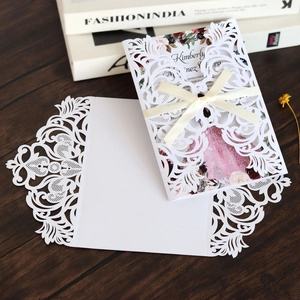 Détail de l'invitation de mariage en dentelle découpée au laser avec ruban de soie