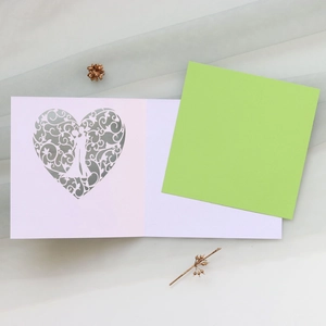 Detailed laser-cut heart card with couple silhouette and delicate floral patterns