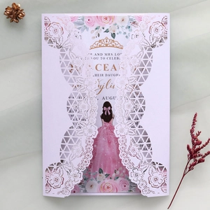 Dettaglio dell'invito in pizzo tagliato a laser con design di un abito rosa quinceañera