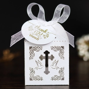 Detailed laser-cut white favor box with cross, peace doves, and elegant ribbon bow