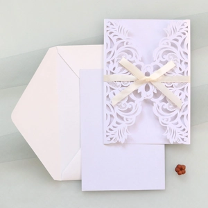 Détail de l'invitation de mariage ivoire découpée au laser avec dentelle et ruban satin